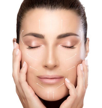 A woman holding here face showing signs of a facelift